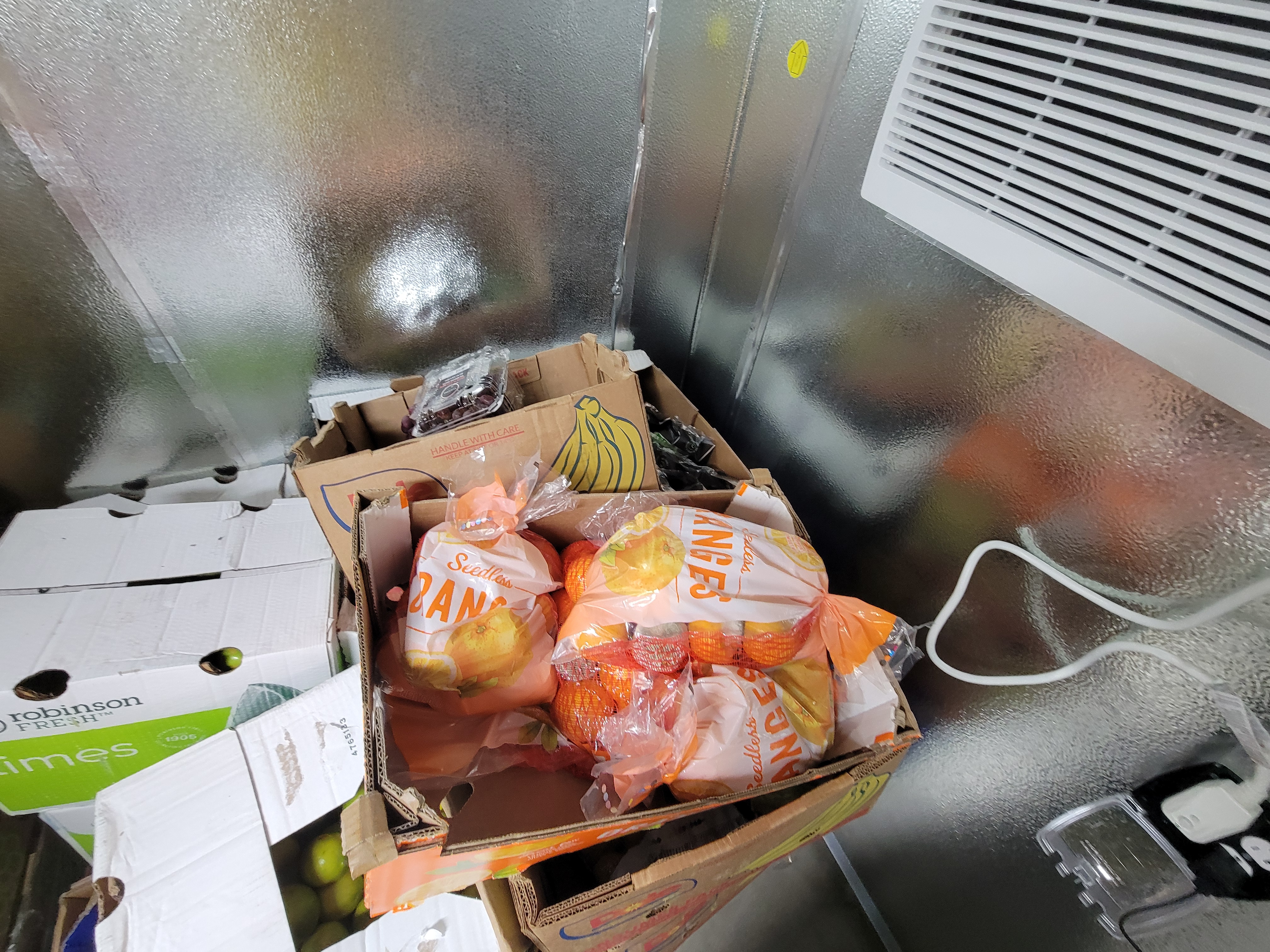 Produce filled boxes in a box fridge unit.